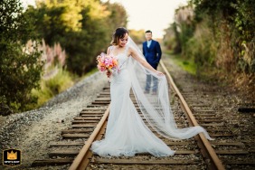 Wedding day portrait of the bride and groom on railroad tracks in Capitola, California.